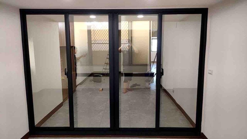 1) 照片顯示一個有三個黑色框架的玻璃門,每扇門都有一個把手