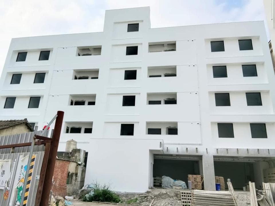 1) 這是一張白色建築物的照片,建築物有許多窗戶,以及一個像停車場的區域