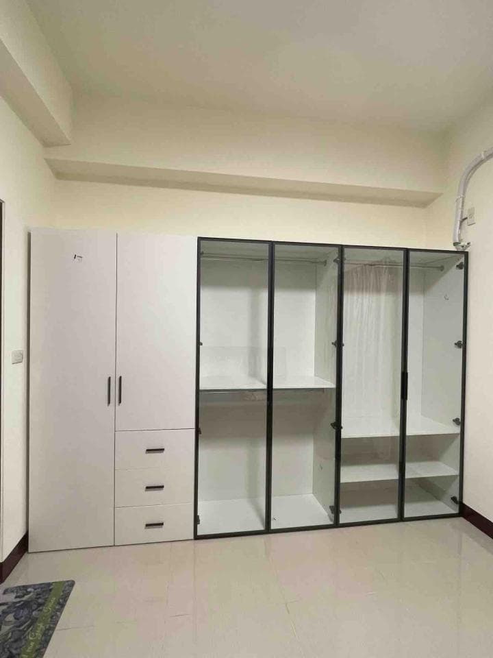 1) 照片顯示一個白色和黑色的現代衣櫃,衣櫃的左邊是兩個門,上面有一個抽屜