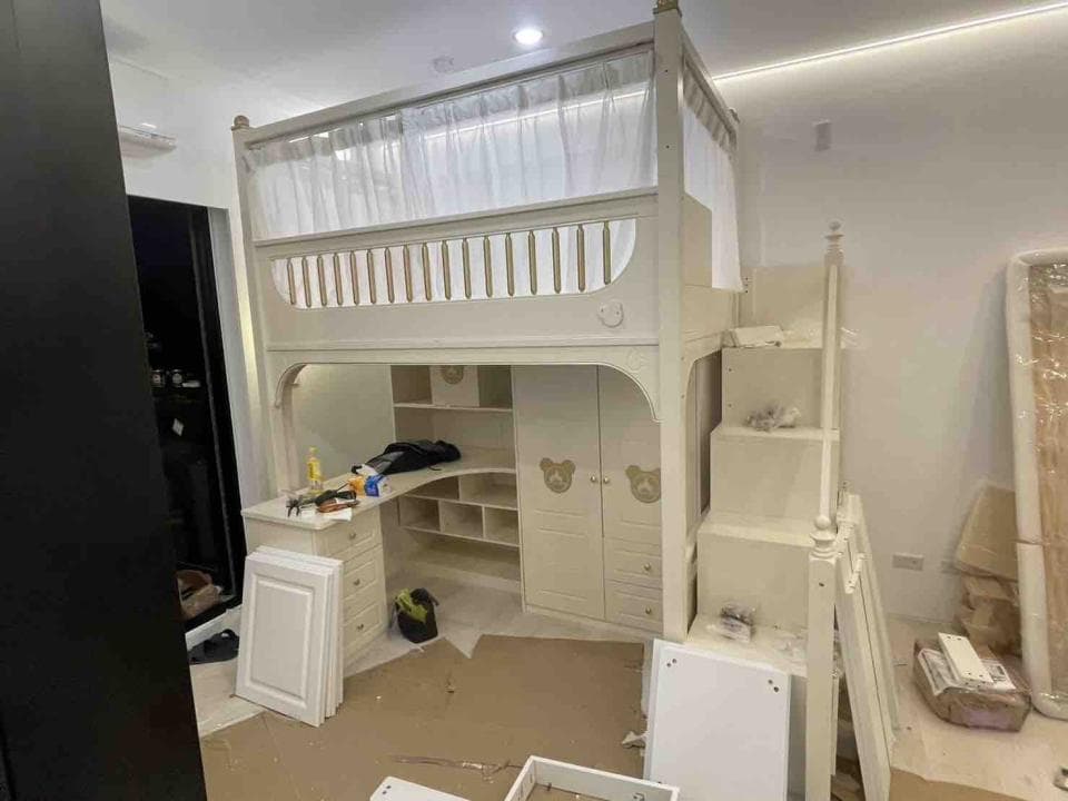 1) 照片顯示一間兒童臥室,其中有一張架高的床,床邊有樓梯