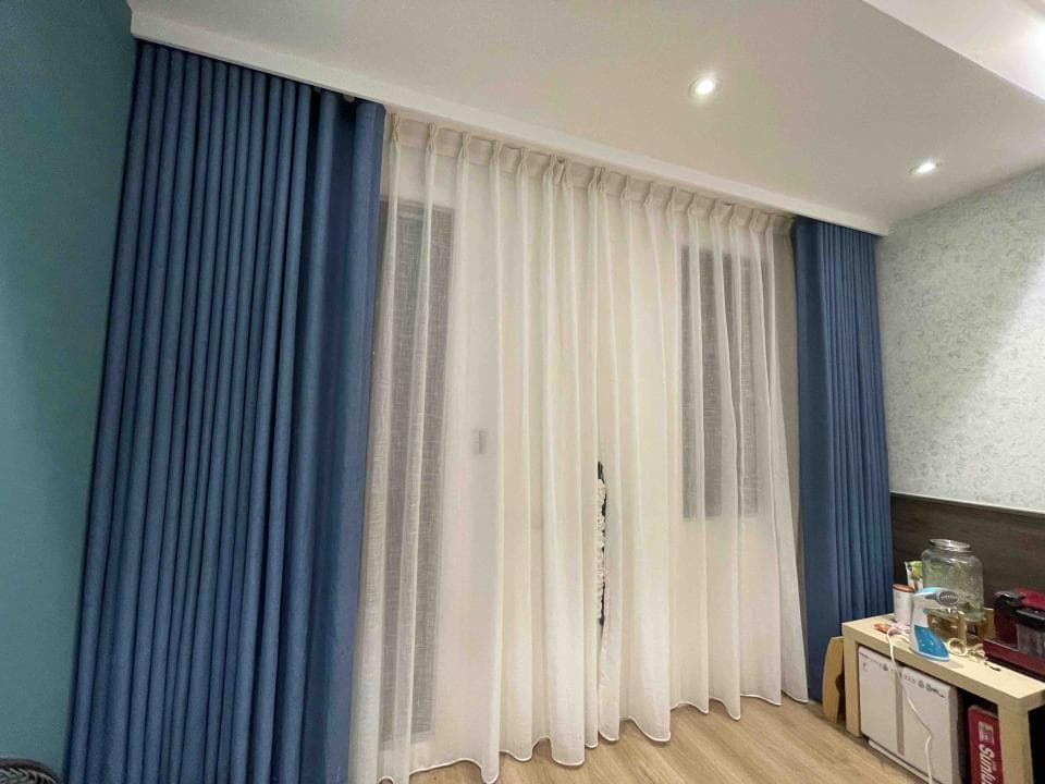 1. 這張照片顯示的是一個房間的窗戶,窗戶上裝有藍色和白色的窗簾