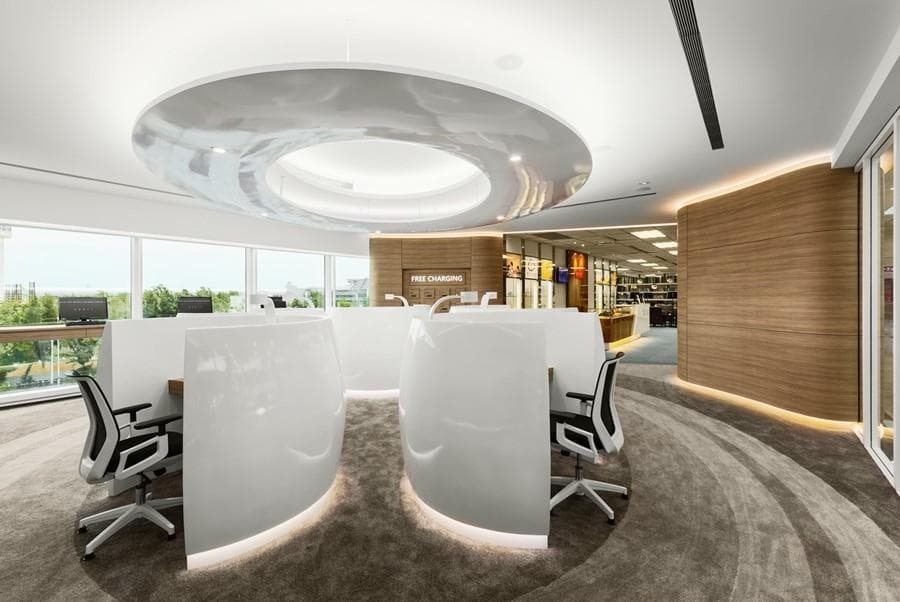 這張「辦公室」的照片是現代化的辦公空間,有白色流線型的辦公桌和椅子,以及木質牆壁和地板。