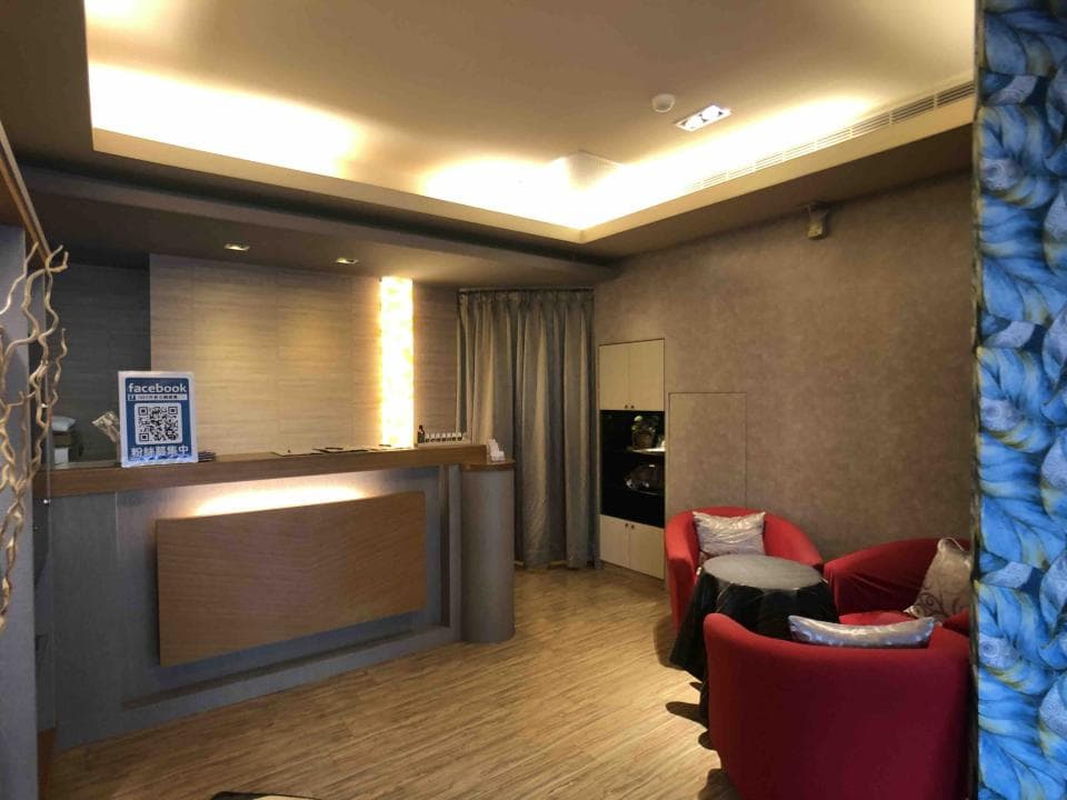 這張「酒店大廳」的照片是,左側是接待櫃臺,右側是沙發和茶几,房間裡還有窗簾和燈光。