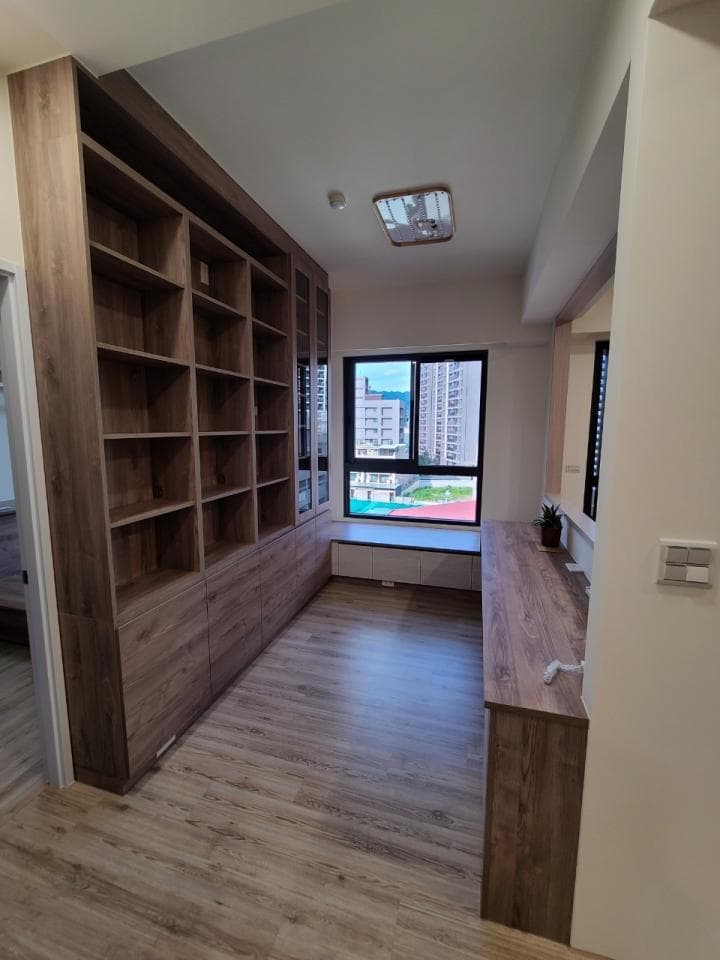 這張「書房」的照片是一間帶有窗戶的書房,書房有一排大型的書櫃,書櫃下方有抽屜,窗戶旁邊有一個小窗臺。