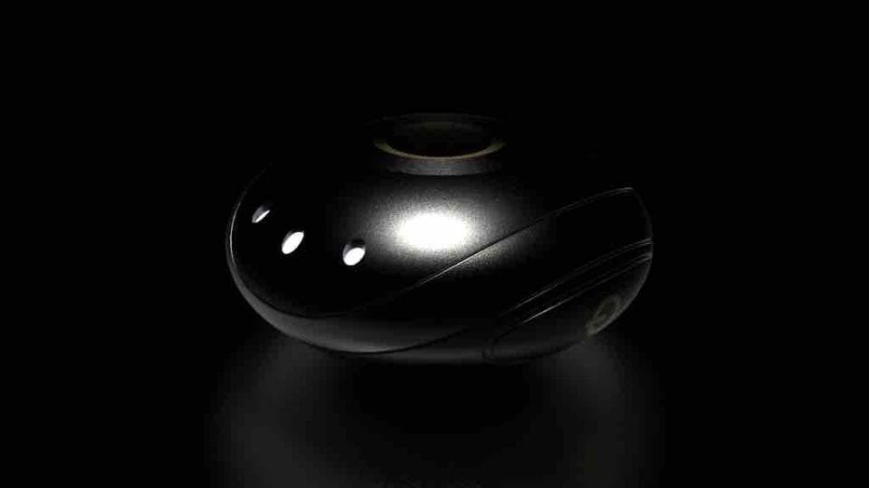 這張「黑色圓形物體」的照片是,它上面有幾個小孔,像是一個裝飾品。