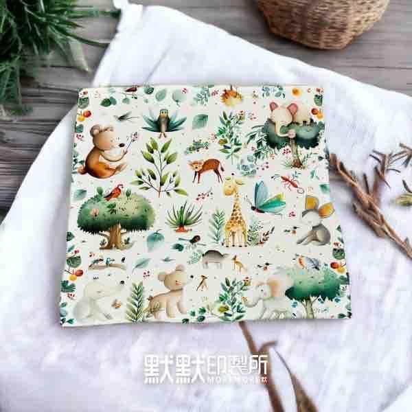 這張照片是一塊印有可愛動物圖案的布料,上面有小熊、長頸鹿、大象和蝴蝶,以及一些綠色植物和紅色漿果,看起來十分可愛。