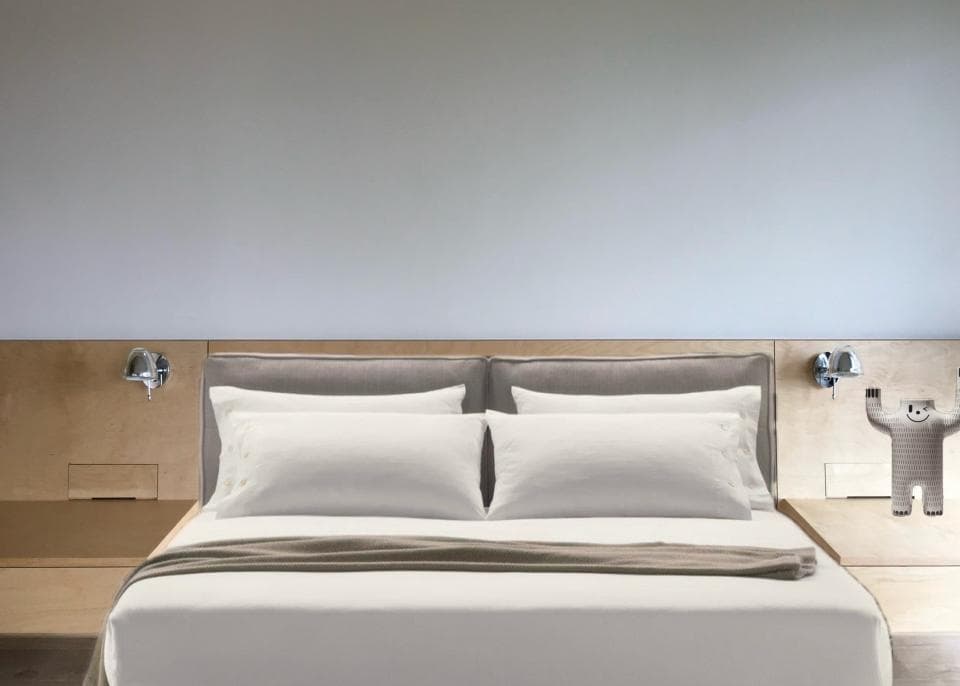 這張「臥室」的照片是一張雙人床,床上鋪著白色床單和褐色床罩,床頭板上裝著兩盞壁燈。