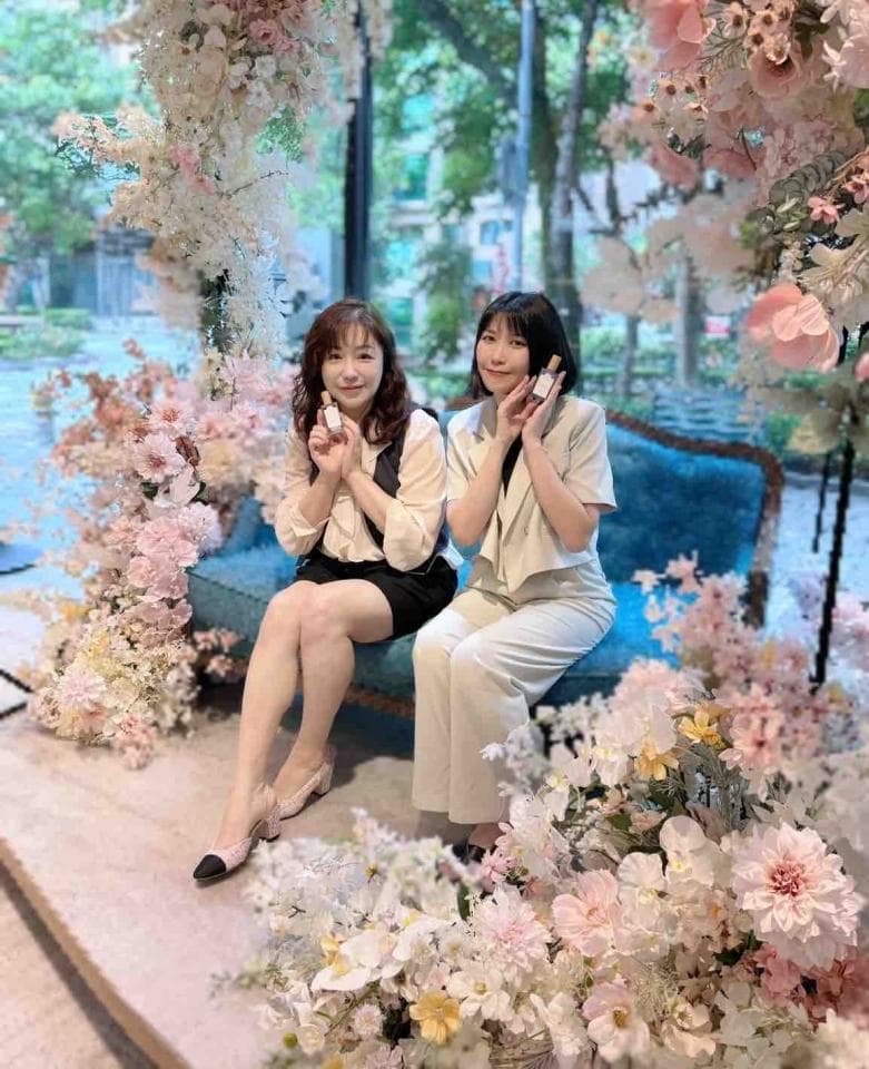 這張「兩個女生坐在藍色沙發上,周圍佈滿粉紅色花朵」的照片是。