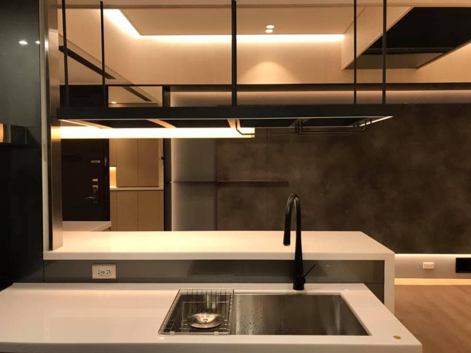 這張「廚房」的照片是一個現代化的廚房,有黑色的金屬架、白色的流理臺、水槽和黑色水龍頭。