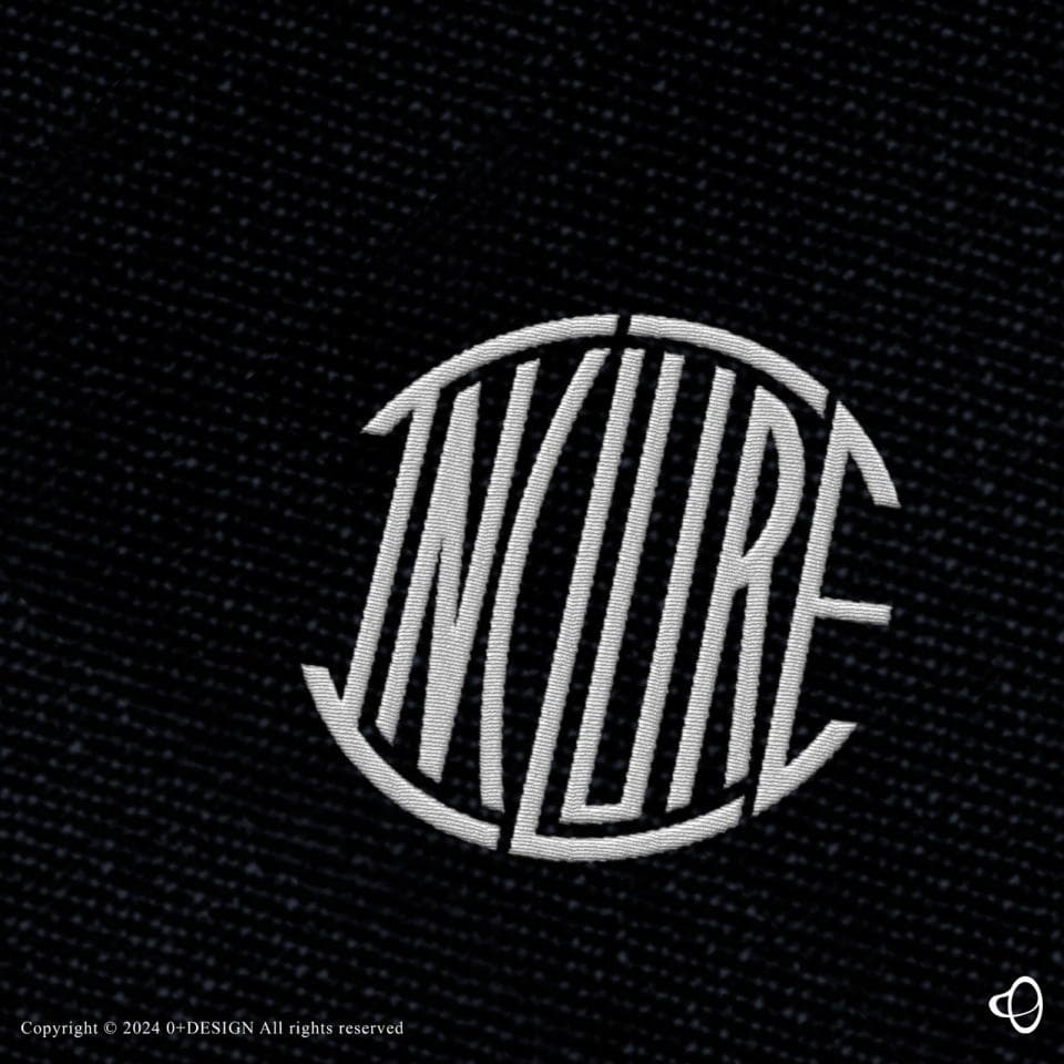 這張「INKLURE」的照片是白色字體繡在黑色布料上的圓形圖案。