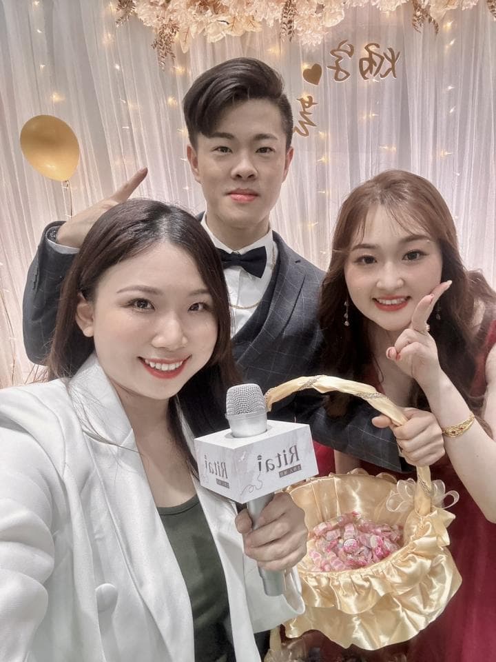 這張「婚禮」的照片是三位朋友,其中一位手拿麥克風,另一位手持花籃,而中間的男士則穿著西裝。