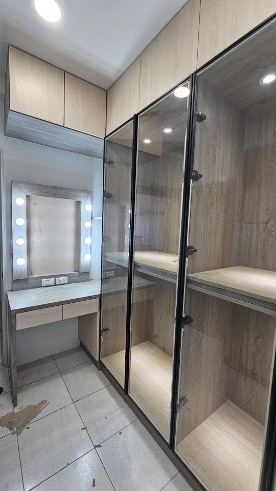 這張「衣櫃」的照片是一個現代化的臥室衣櫃,它有玻璃門和黑色邊框,內部有木質層板,可以用來存放衣服和其他物品。