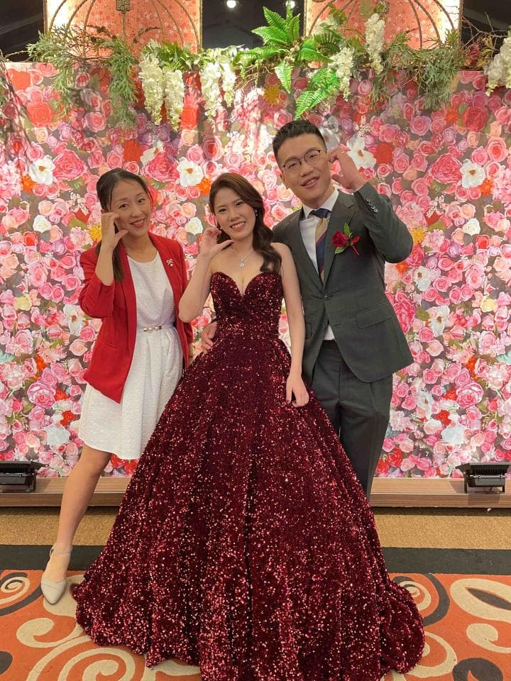 這張「婚禮」的照片是三個朋友在婚禮上合影,其中一位穿著紅色禮服,一位穿著深色西裝,一位穿著白色禮服。