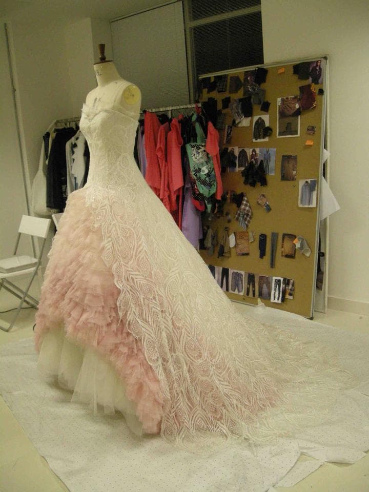 這張照片是一件蕾絲婚紗,裙擺很長,上面有粉色花邊,看起來很漂亮。