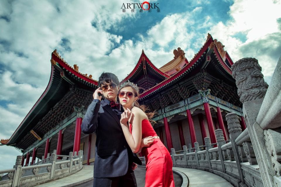 這張「婚紗照」的照片是一對情侶在中國風建築的背景下,他們看起來很幸福,女方穿著紅色禮服,男方穿著西裝。