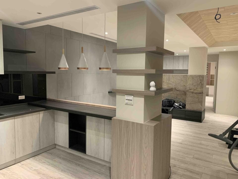 這張「現代化廚房」的照片是,包含了木質櫥櫃、黑色檯面和三盞金屬吊燈,一旁是放置裝飾品的木質層架。