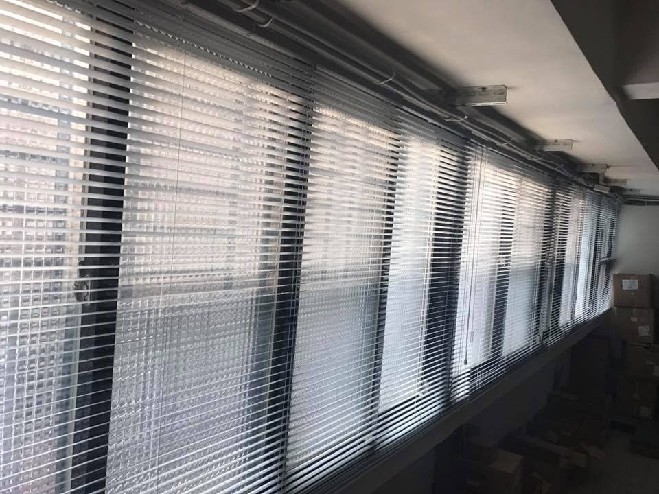 1) 照片顯示了一排白色百葉窗,窗戶上有灰色的陰影,似乎是從外部照射進來的光線