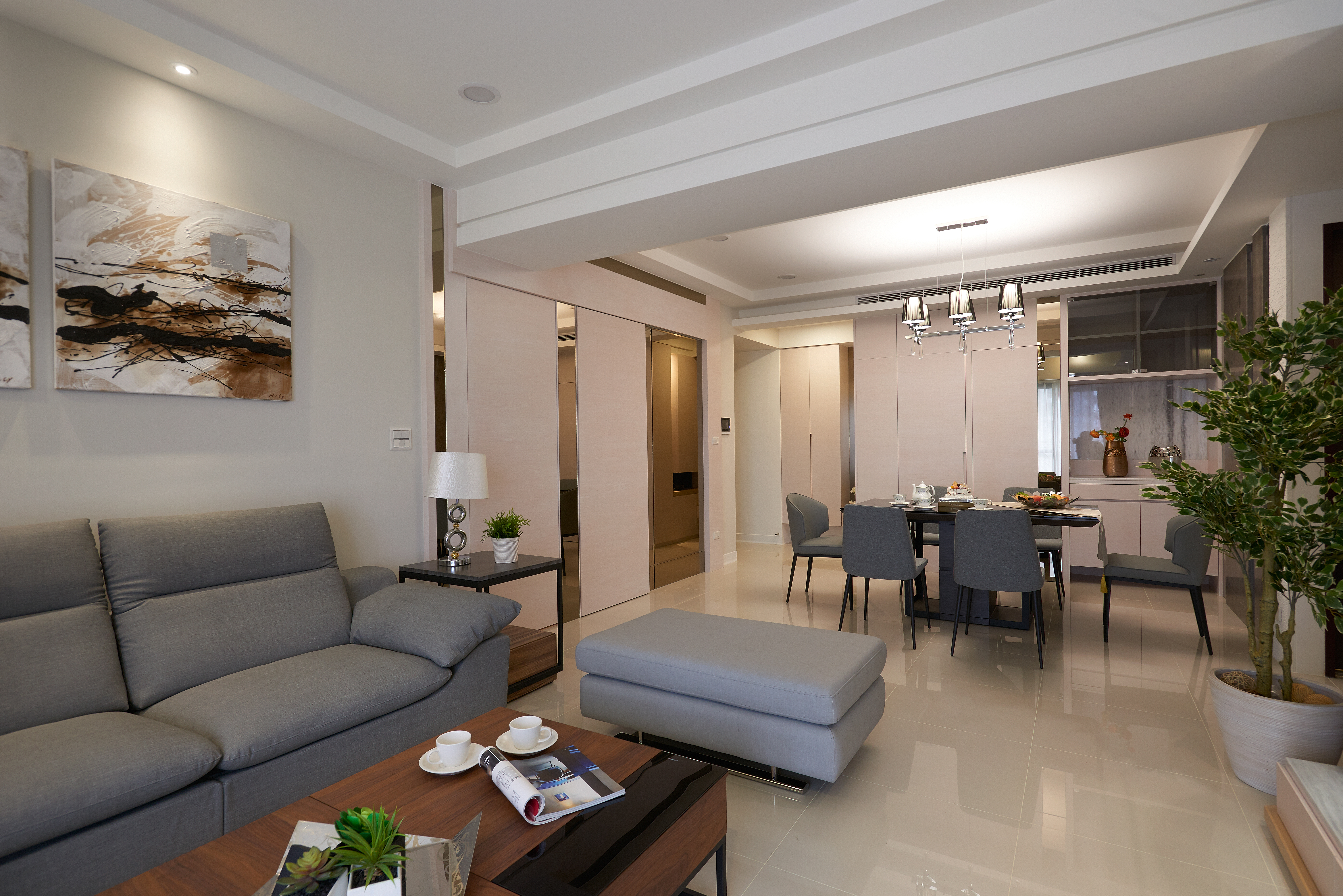 這張「現代化客廳」的照片是一間寬敞的客廳,佈置簡潔,色調統一,客廳中央放著一張灰色沙發,沙發前有一張木質茶几,客廳的左側還有一張灰色的長凳。