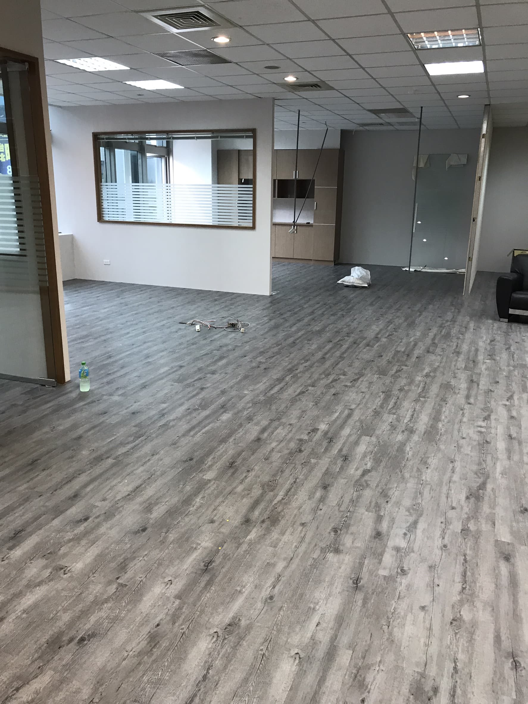 1) 這是一張空蕩蕩的辦公室照片,辦公室裡鋪著木紋地板,房間裡沒有任何傢俱