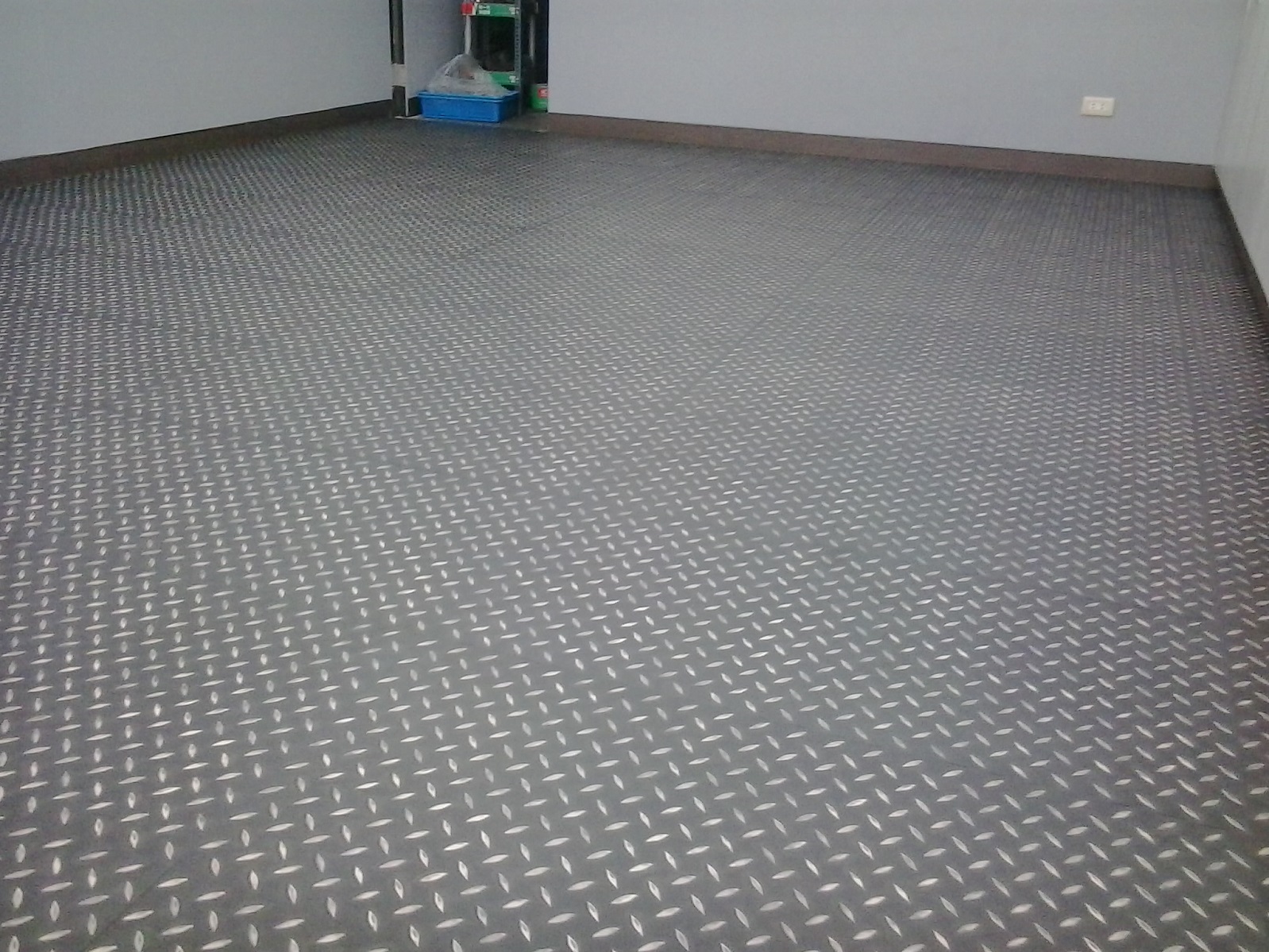1) 照片顯示一個灰色金屬地板,地板上有菱形圖案