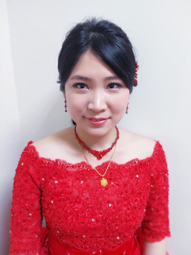 這張「婚紗照」的照片是一個穿著紅色蕾絲禮服的女子,她戴著精緻的耳環和項鍊,表情幸福,充滿喜悅。