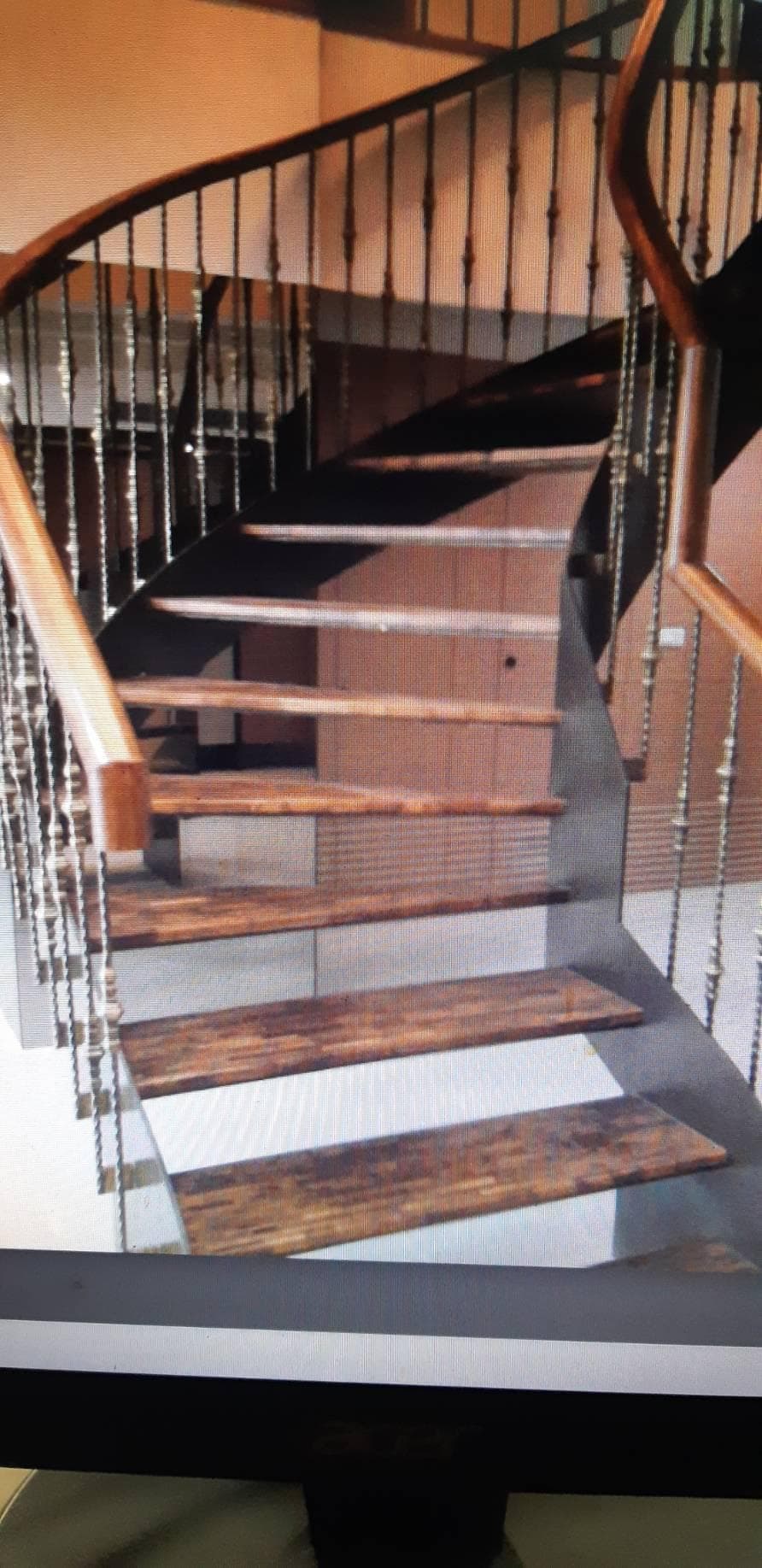 1) 照片顯示一個木製樓梯,帶有金屬扶手