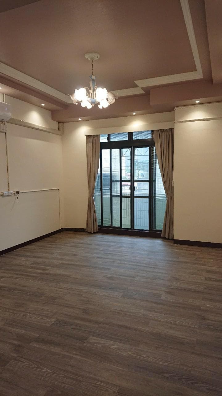 這張照片是一間房間,地板是木紋的,非常明亮寬敞。