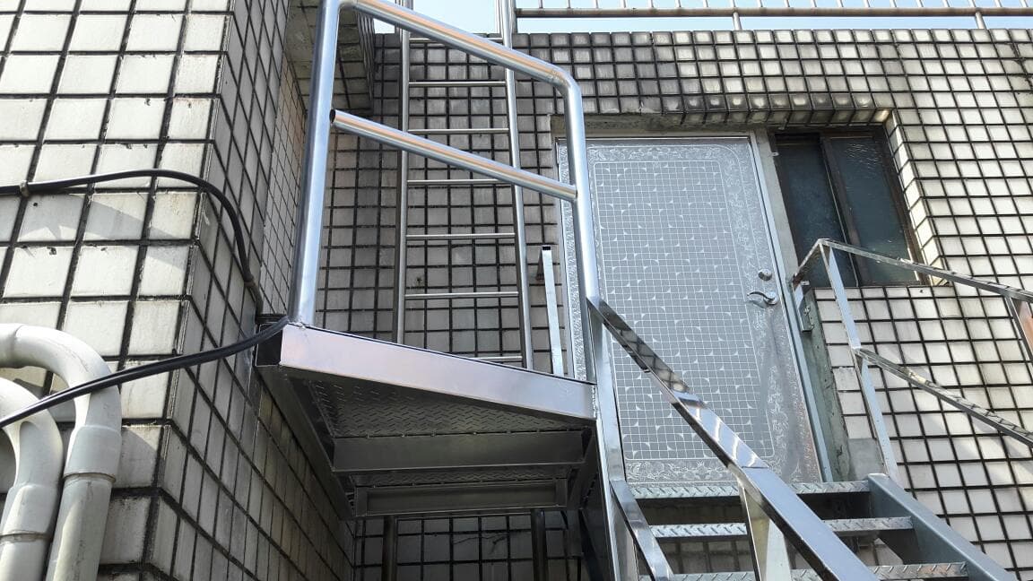 1) 照片顯示一棟建築物上的金屬樓梯和門