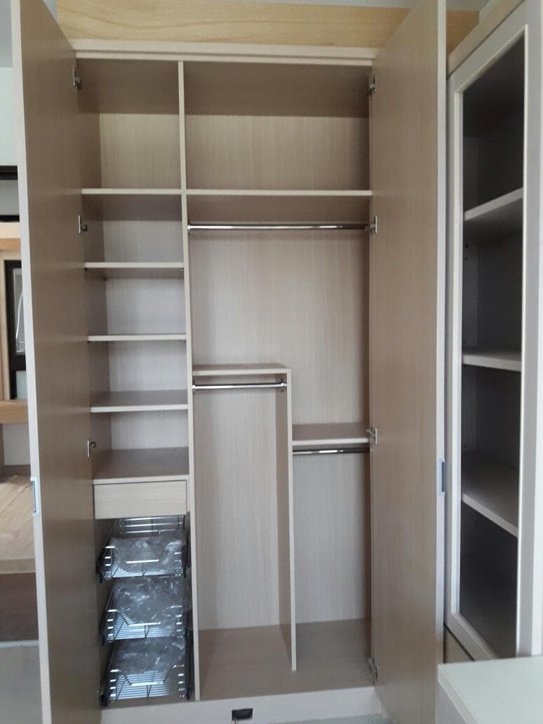 這張照片是一個衣櫥的內部,裡面有許多層架和一個掛衣服的桿子。