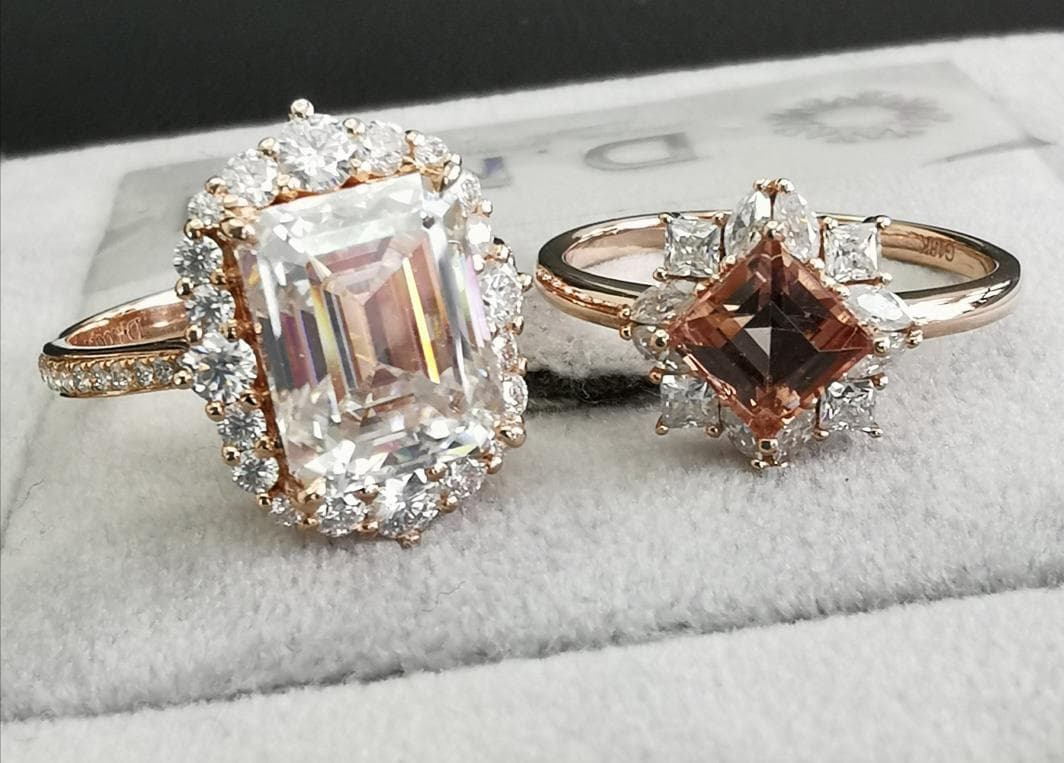 1) 這張照片顯示了兩個戒指,一個有方形的寶石,一個有方形的寶石,兩者都有很多小鑽石