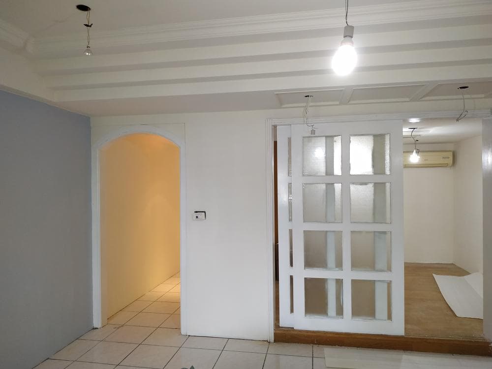 1) 照片顯示一個房間的內部,房間牆壁塗上了淺灰色,房間有拱形門、一個隔板門和一個吊燈