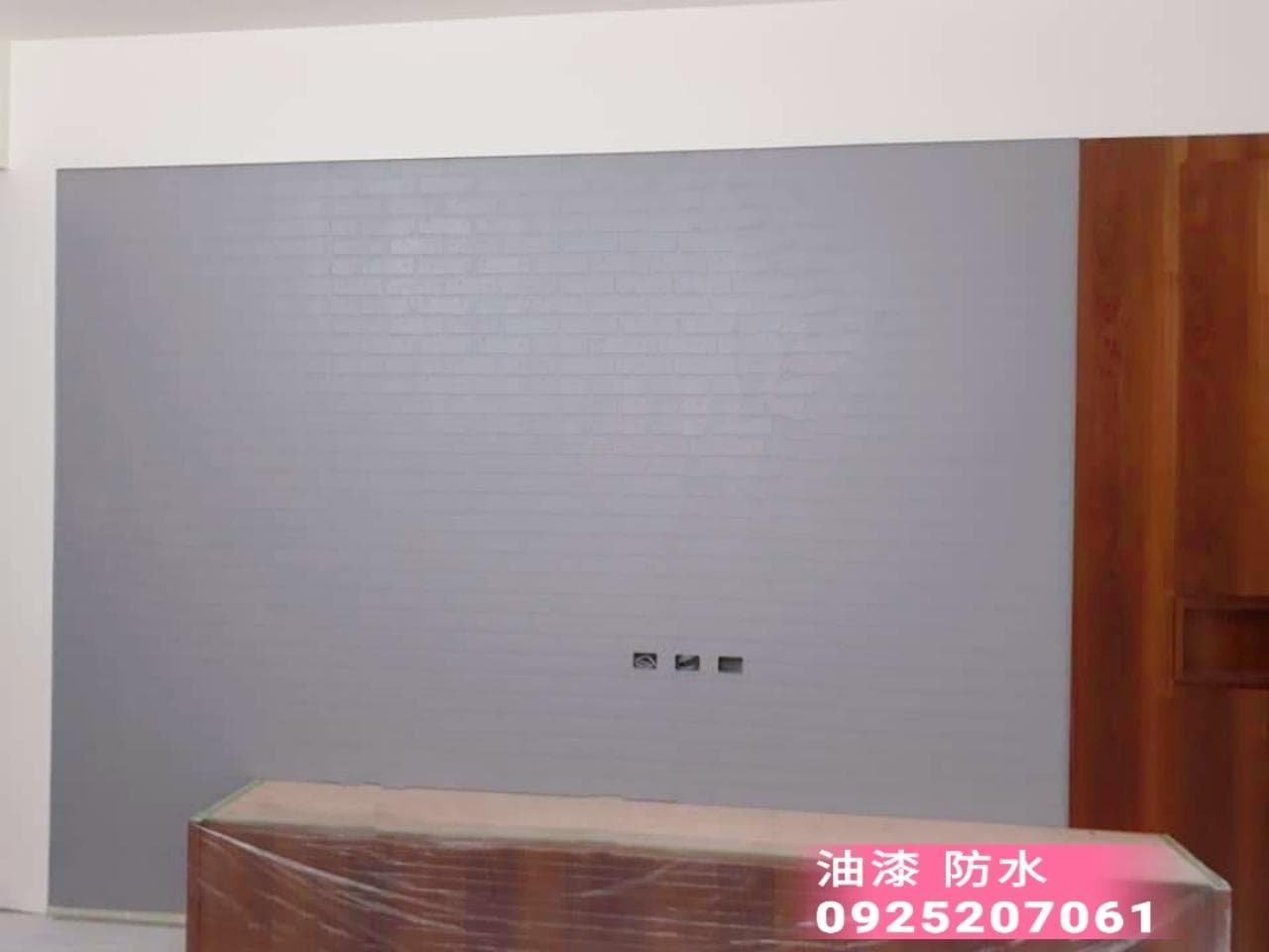 1. 照片顯示一間房屋的牆壁,牆壁上鋪設著灰色的防水油漆