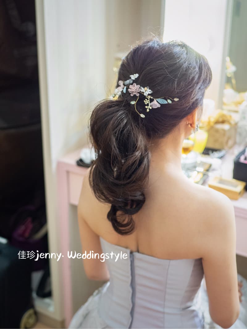 這張「新娘準備婚禮」的照片是,一位穿著白色禮服的新娘,她正在整理頭髮,戴著頭飾。