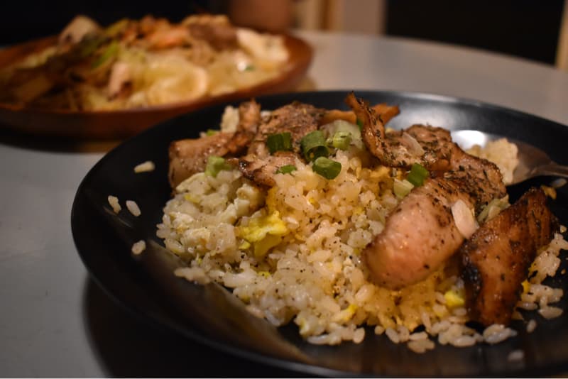 這張照片是一盤香噴噴的豬肉炒飯,上面放著幾片焦香的豬肉,還有少許蔥花,看起來非常可口。