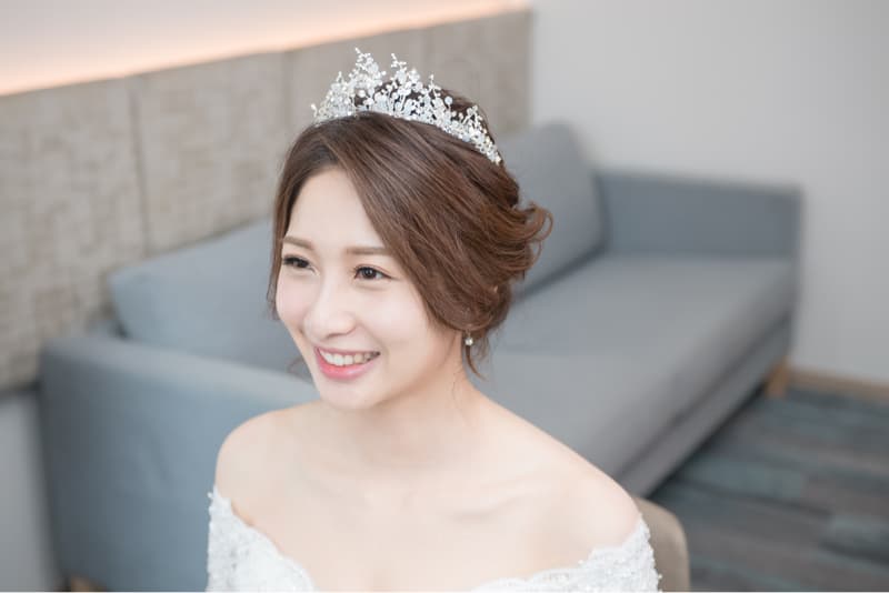 這張「新娘」的照片是一個穿著婚紗、戴著皇冠、露出幸福笑容的女性。