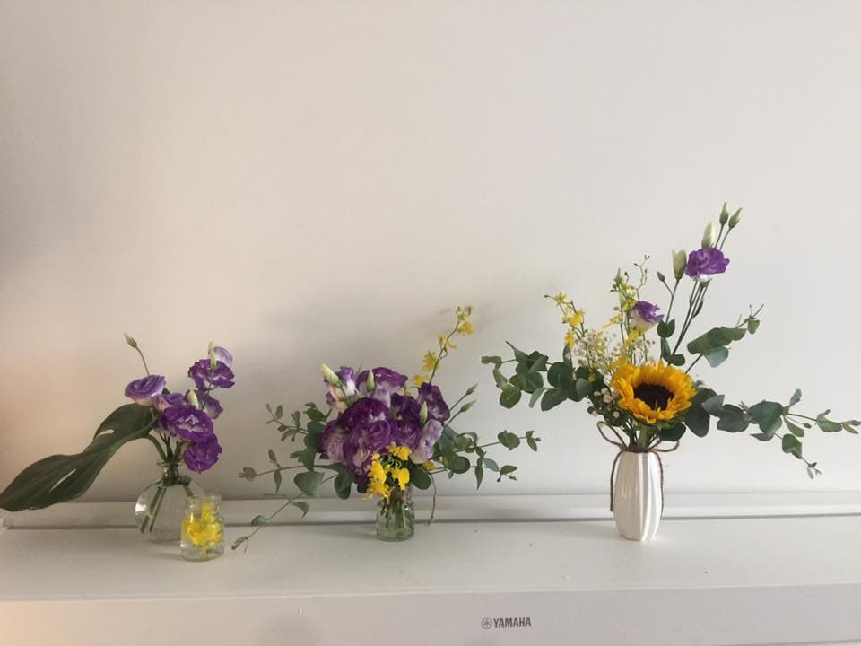 1) 照片顯示了三個花瓶中的花朵,其中兩個花瓶中裝的是紫色的花,另一個花瓶中裝的是向日葵