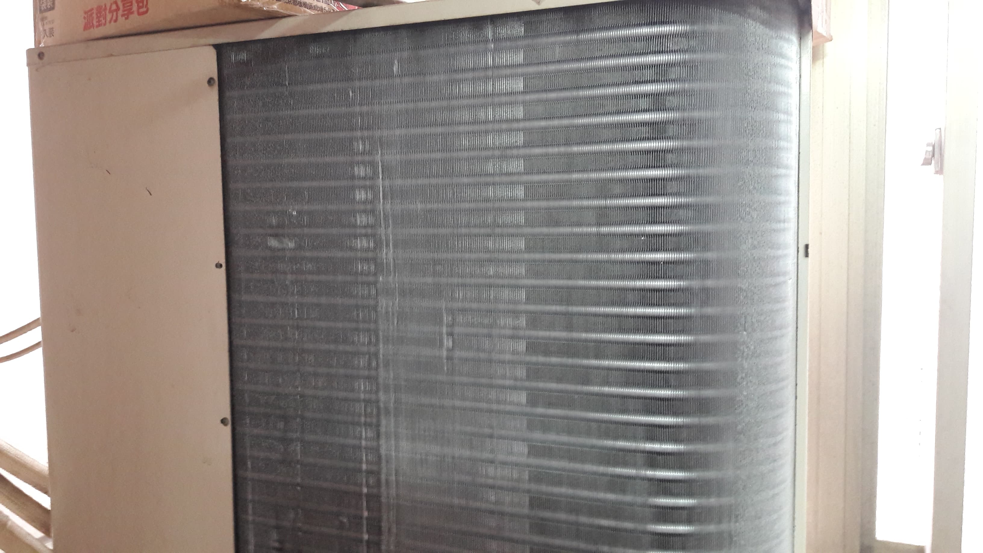 1) 照片顯示一個外部冷氣機組的冷凝器