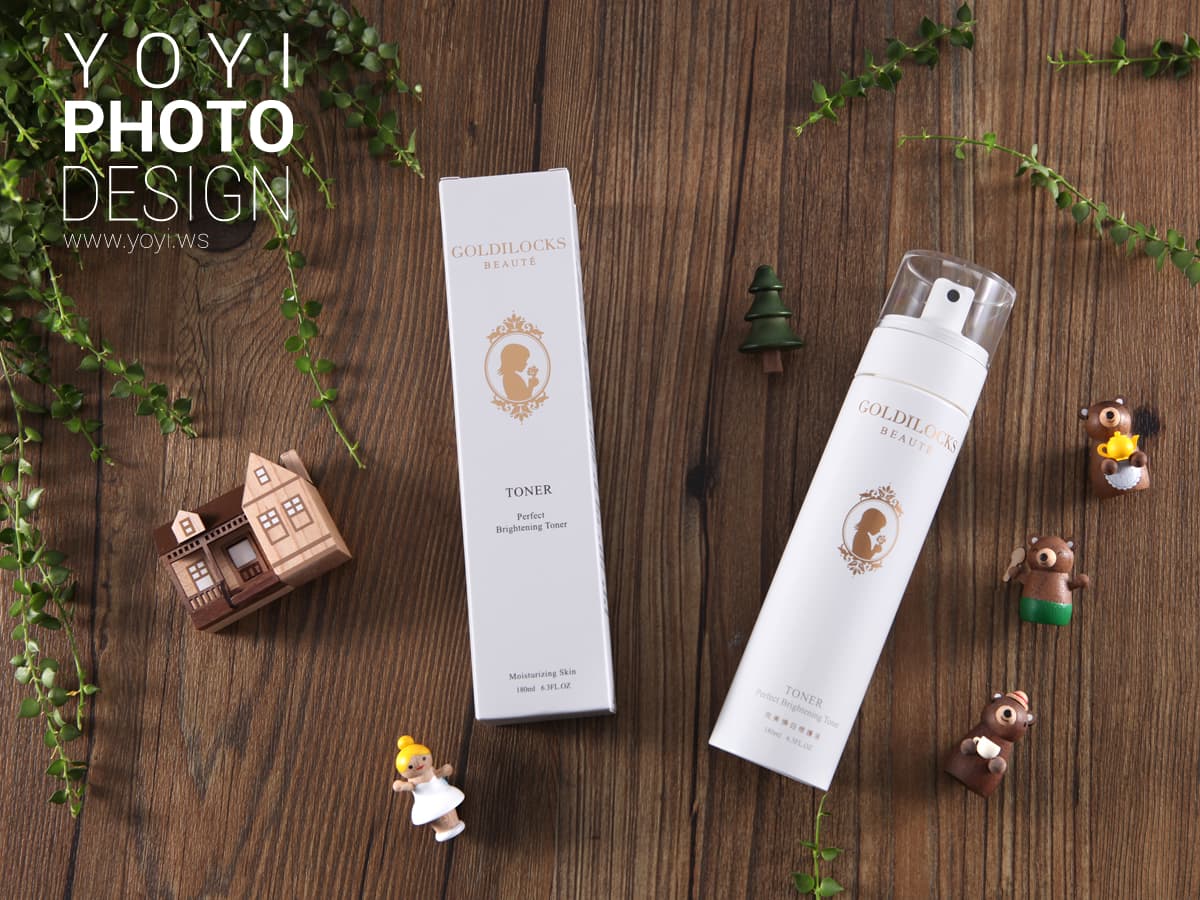 這張照片是兩瓶化妝品,一瓶是精華液,另一瓶是噴霧,都印有金色的小女孩圖案,看起來很精緻。