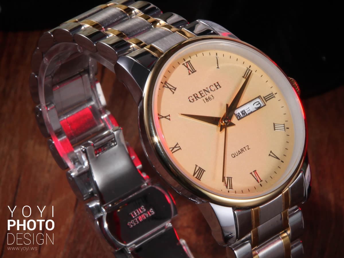 這張照片是一個金色和銀色的手錶。手錶的錶盤是淺色的,上面有黑色的數字和指針,以及 GRENCH 1861 的品牌名稱。錶盤上還有 QUARTZ 和一個日期顯示窗。