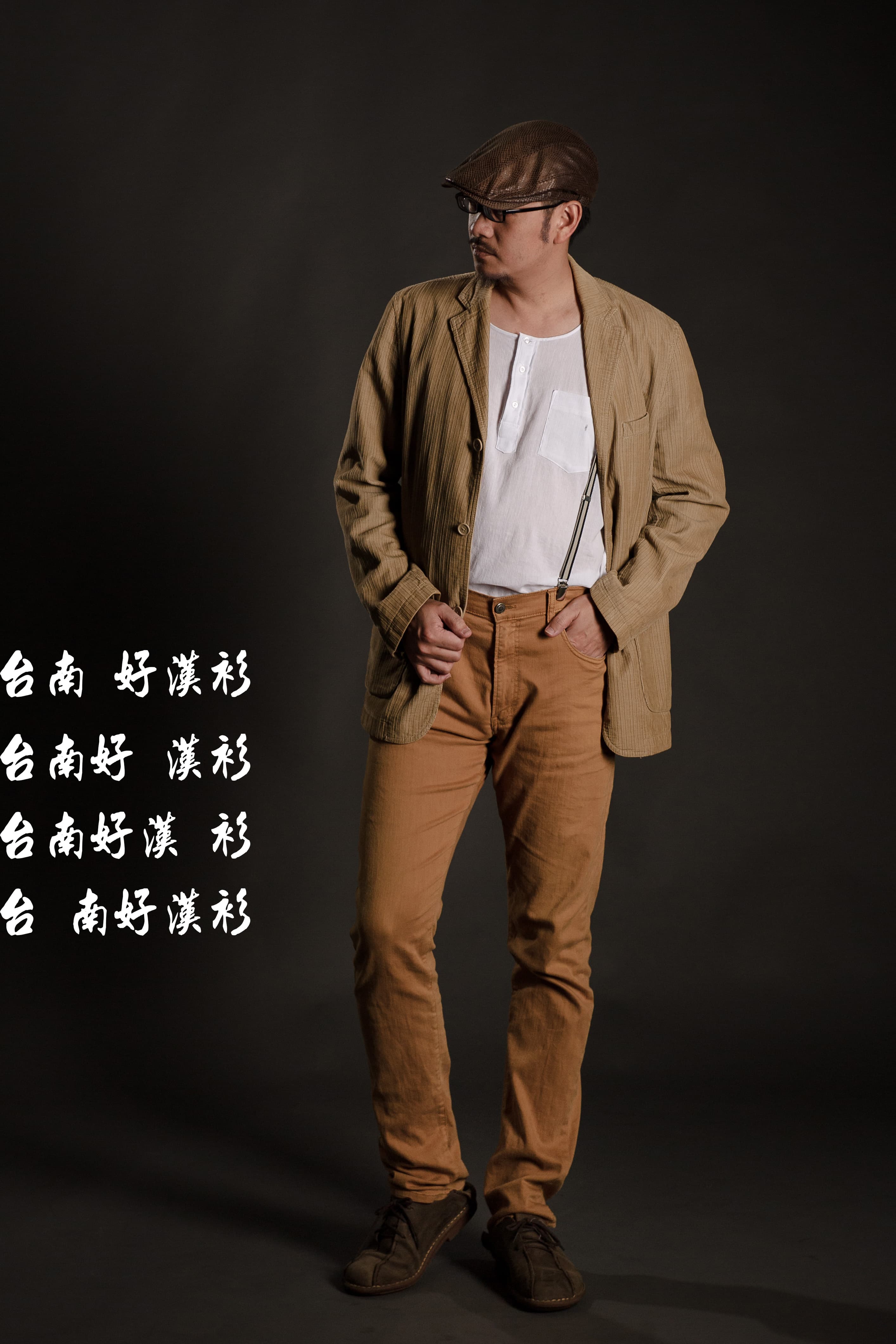 這張「時尚街拍」的照片是一位男士穿著棕色外套、棕色褲子和紳士帽,他站在深色背景前,看起來很時髦。