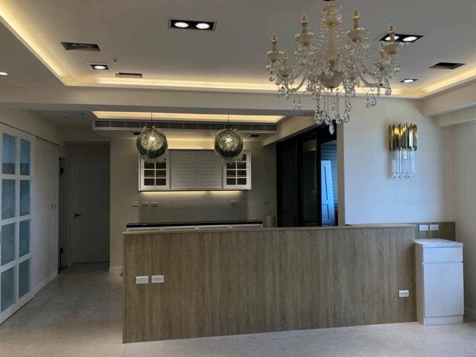 這張照片是一間現代化的廚房,其中最引人注目的部分是中間的木質吧檯,它巧妙地將空間分隔,既美觀又實用。