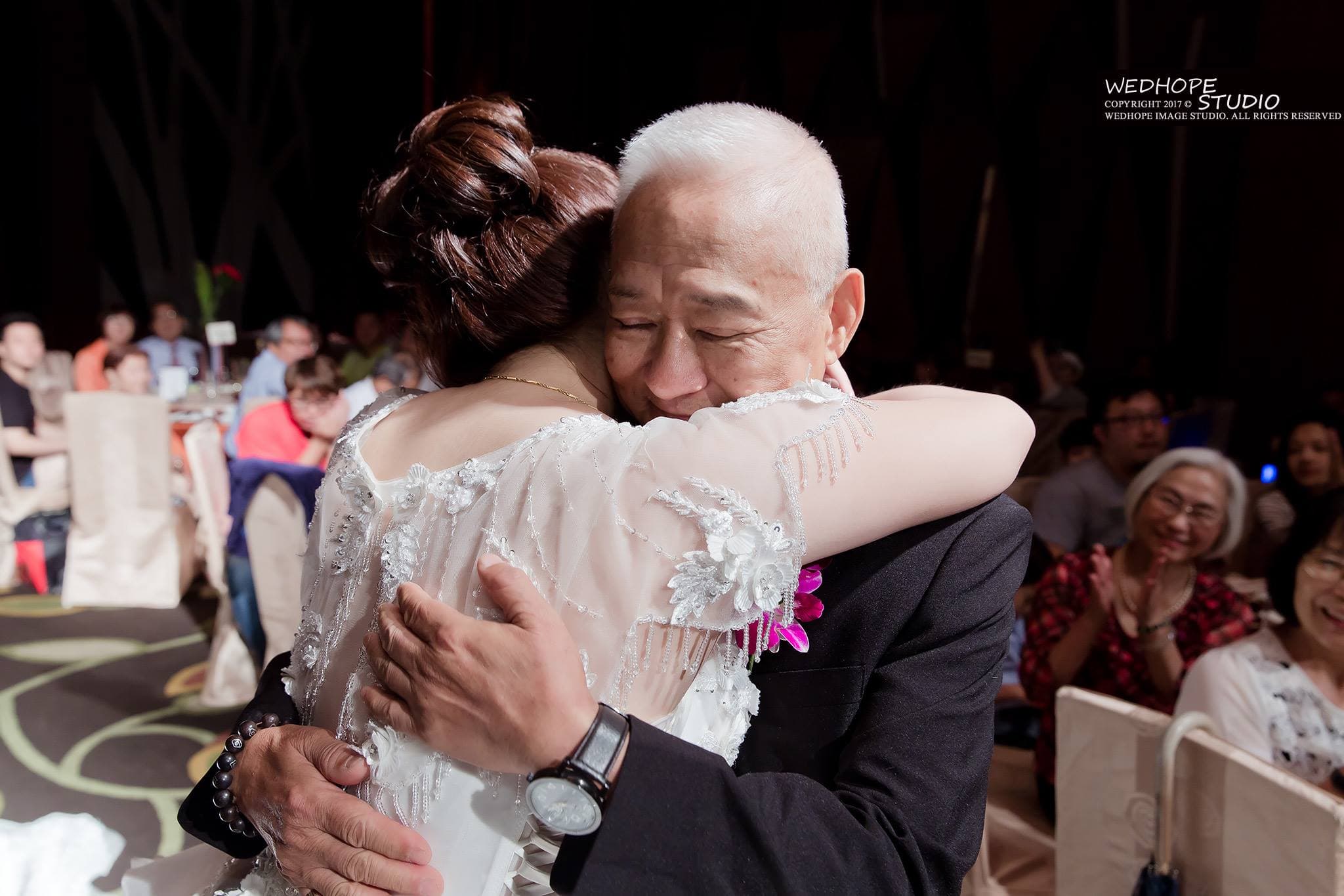 這張照片是一個父親緊緊擁抱他即將出嫁的女兒,他們都露出真誠的笑容,充滿著幸福與不捨。