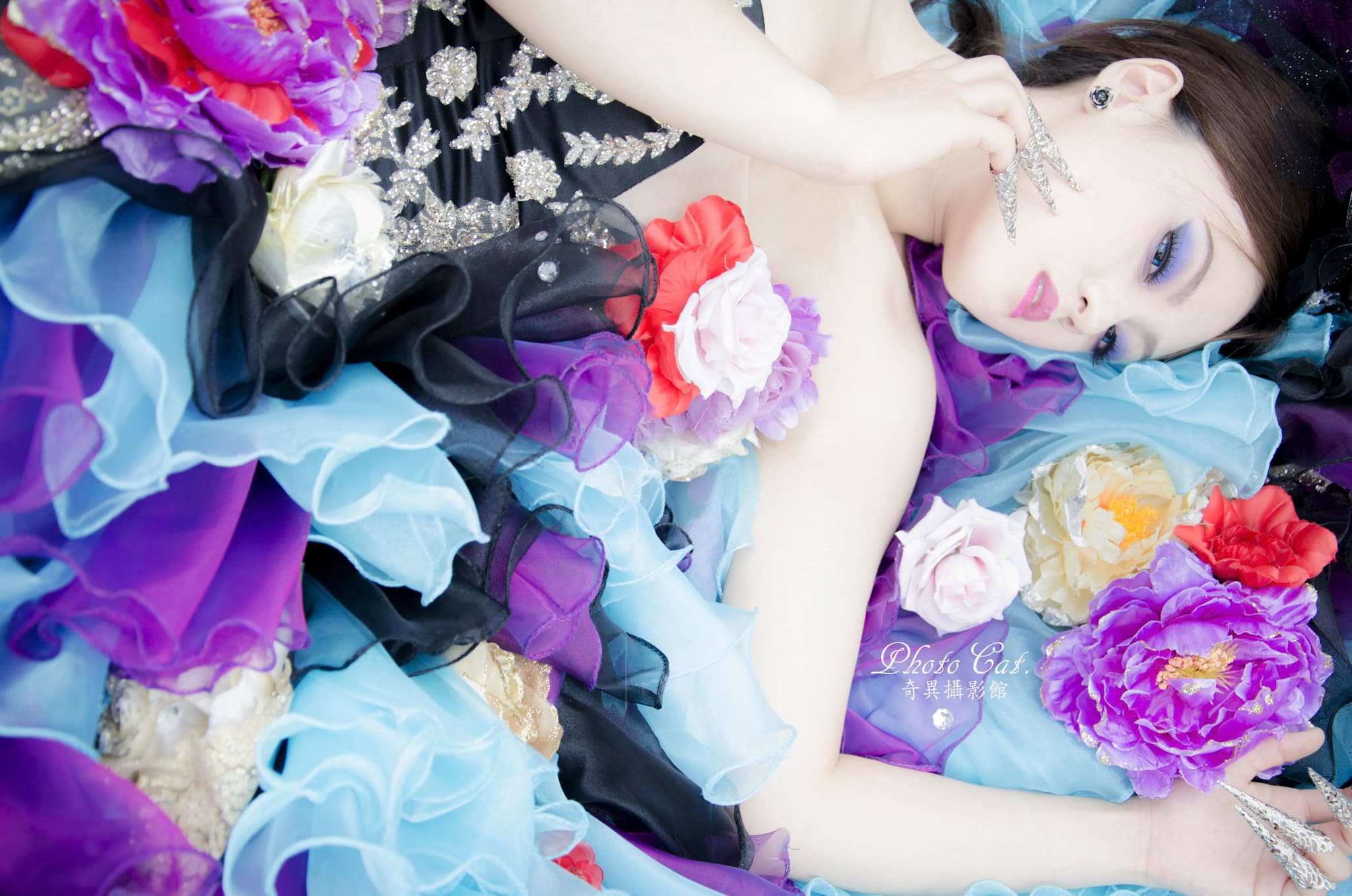 這張「婚紗照」的照片是一個穿著白色婚紗的女孩,她躺在一張床上,周圍佈滿了許多花瓣。