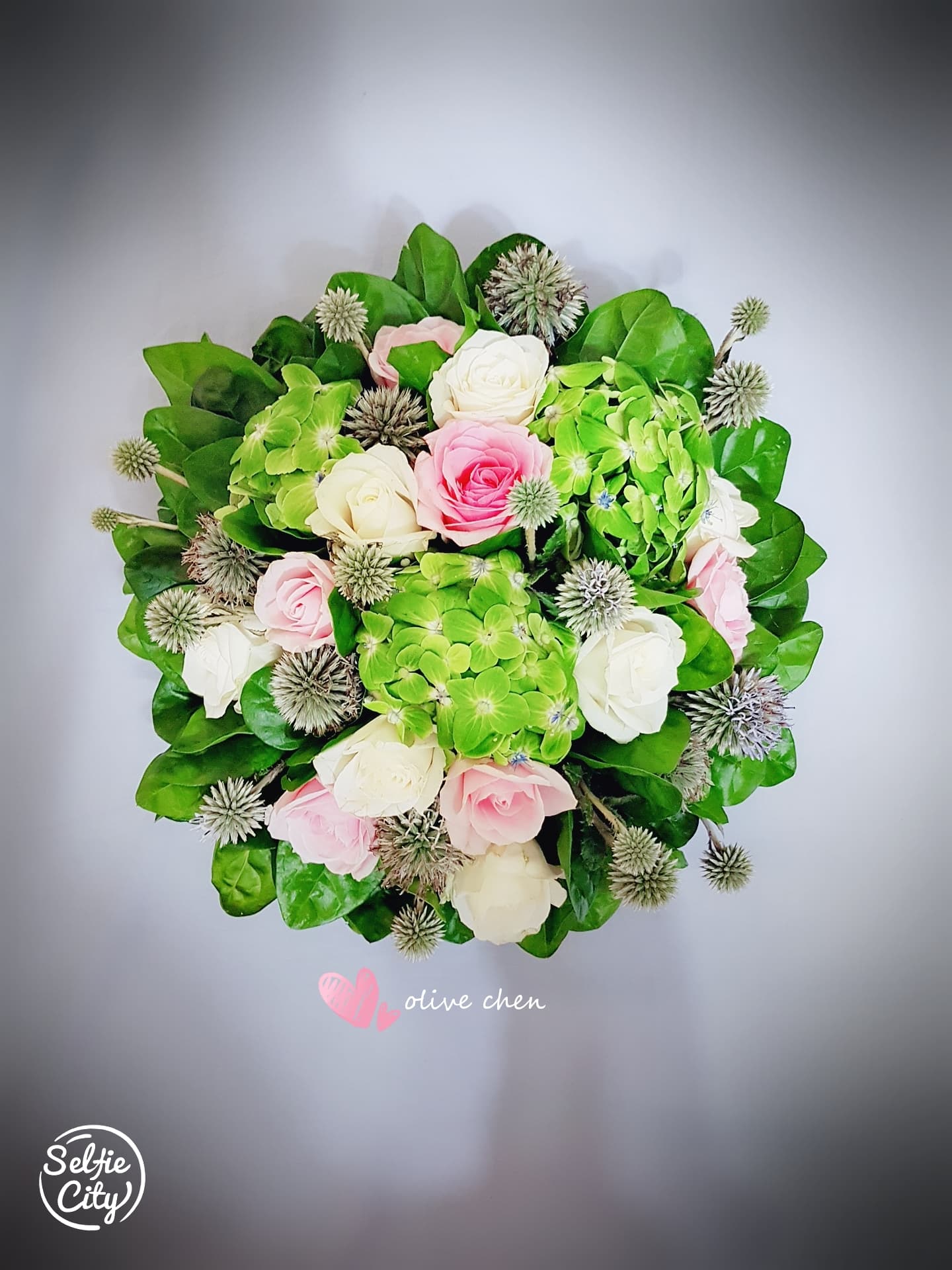 1) 照片中是一個由粉色和白色的玫瑰以及綠色植物組成的花束