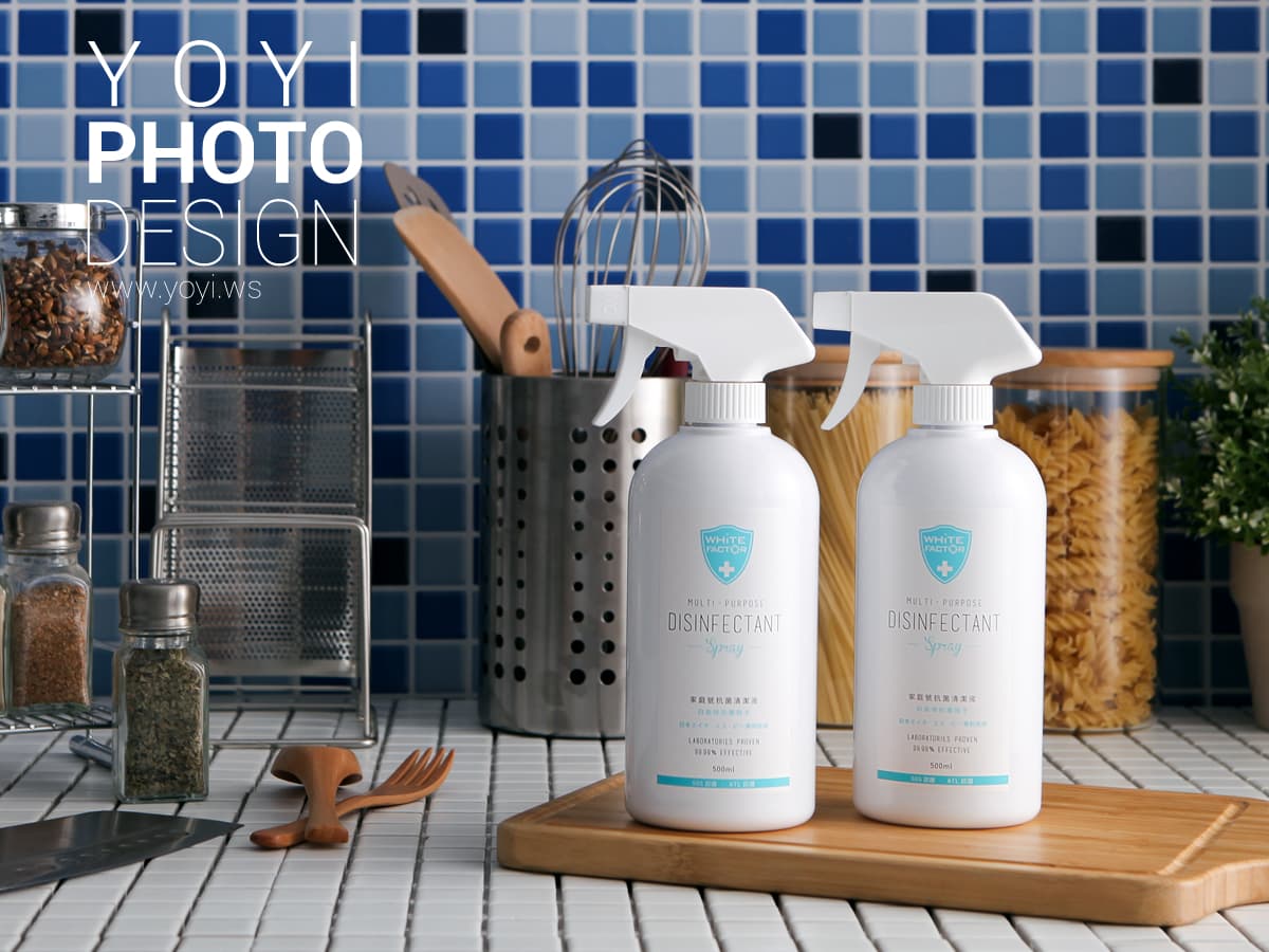 這張照片是兩瓶消毒噴霧,放在一個木製的底座上,背景是一個藍色瓷磚牆。