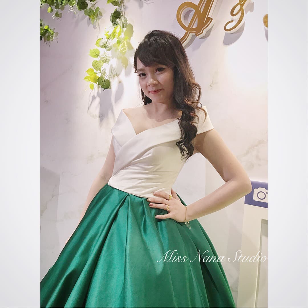 這張婚紗照是一個穿著白色上衣和綠色裙子的女孩。