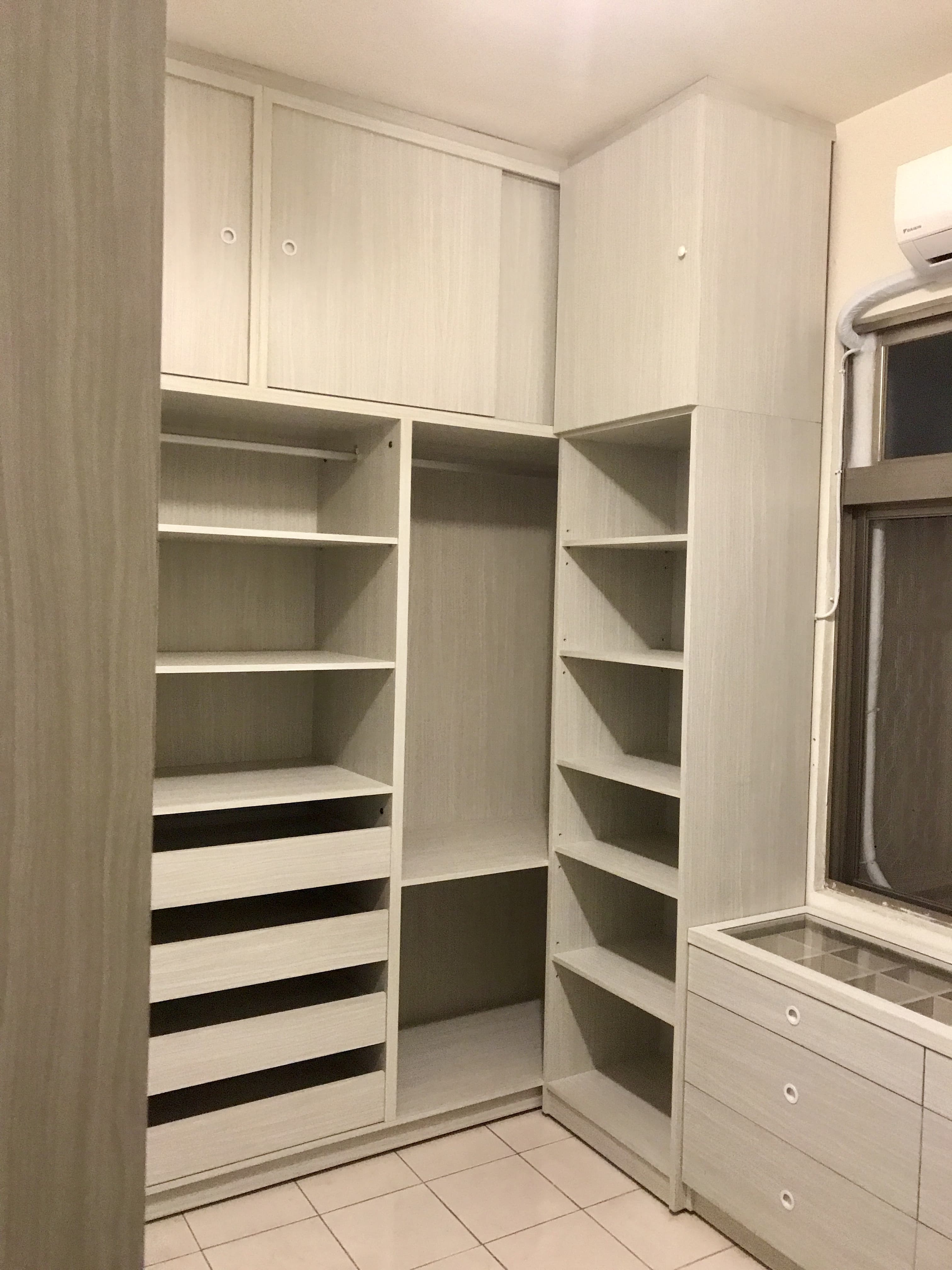 這張照片是一個大型衣櫃,它有許多抽屜和隔板,可以方便地存放衣物和其他物品。