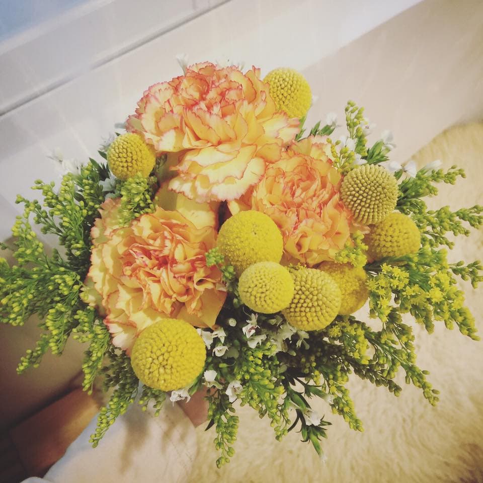 這張「花束」的照片是一束由黃色和橙色康乃馨以及其他黃色小花組成的美麗花束。
